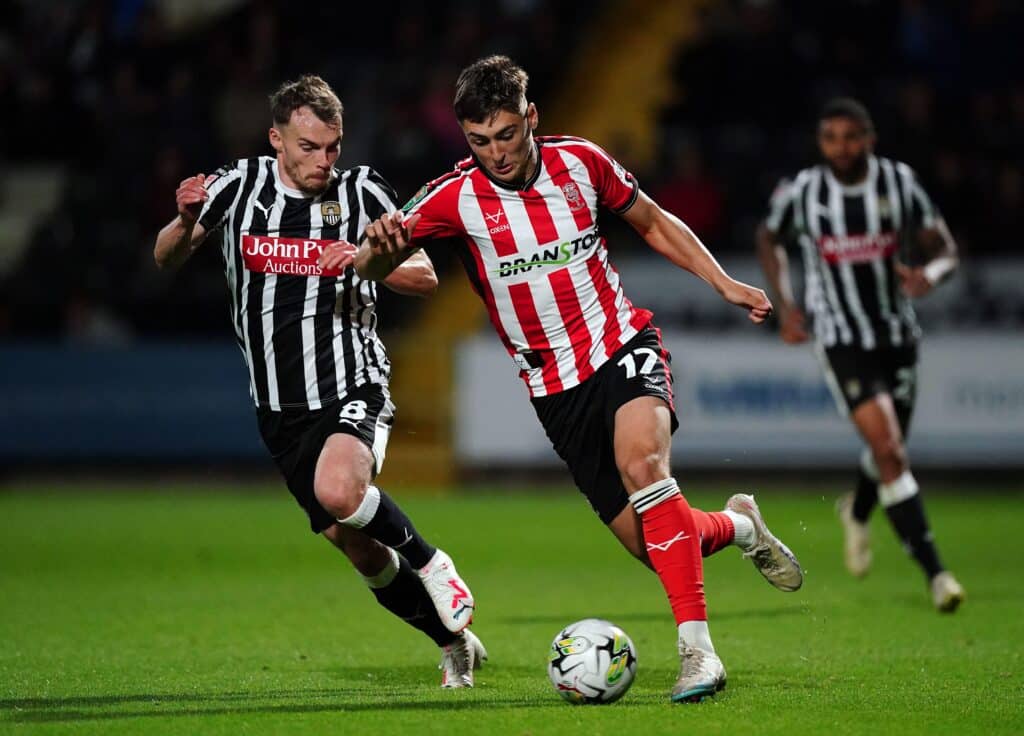 Notts County's Sam Austin and Lincoln City's Dylan Duffy (right) battle for the ball during the Carabao Cup first round match at Meadow Lane, Nottingham. Picture date: Tuesday August 8, 2023.